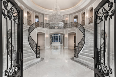 Huge tuscan marble floor, gray floor, tray ceiling and wall paneling entryway photo in Phoenix with gray walls and a metal front door