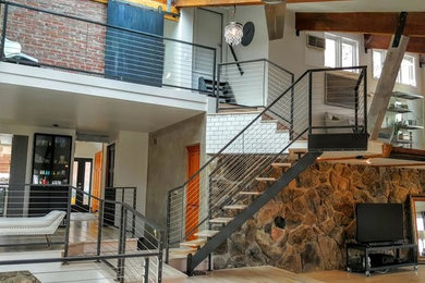 Example of a large urban loft-style light wood floor and beige floor living room design in Denver with no fireplace and no tv