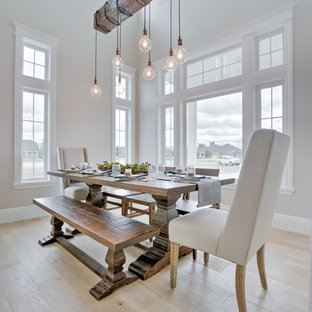 Modelo de comedor de estilo de casa de campo con suelo de madera clara, paredes blancas y suelo beige