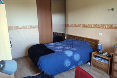 Cette photo montre une grande chambre avec un mur vert, sol en stratifié et un sol beige.