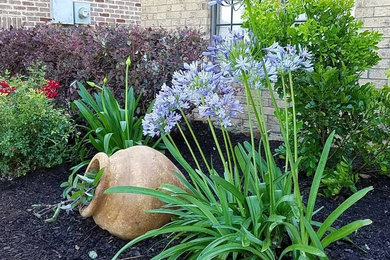 Photo of a mid-sized traditional front yard stone formal garden in Houston.