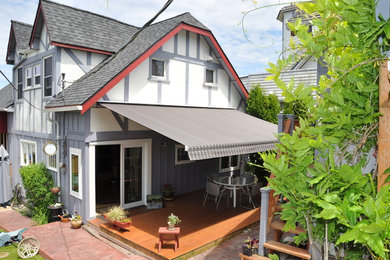 Design ideas for a mid-sized traditional backyard deck in Seattle with an awning.
