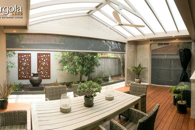 Design ideas for a mid-sized contemporary backyard patio in Sydney with decking and a pergola.