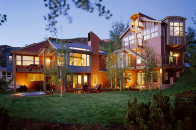 Huge eclectic brown three-story mixed siding exterior home idea in Denver with a clipped gable roof