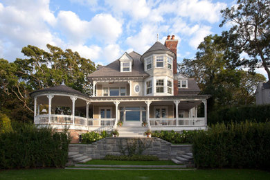 Large ornate yellow three-story concrete fiberboard house exterior photo in San Diego with a shingle roof