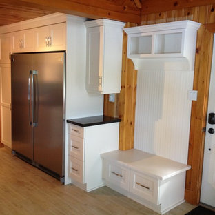 Exemple d'une grande arrière-cuisine craftsman en U avec un évier 2 bacs, un placard à porte shaker, des portes de placard blanches, un plan de travail en quartz, un électroménager en acier inoxydable et un sol en bois clair.