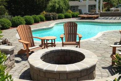 Photo of a mid-sized arts and crafts backyard patio in Other with a fire feature, natural stone pavers and a pergola.