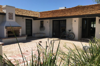 Large 1950s white one-story stucco house exterior photo in Phoenix with a hip roof and a shingle roof