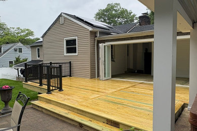 Inspiration for a large backyard ground level metal railing deck remodel in New York