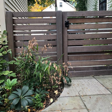 Mahogany garden gate separates driveway from garden