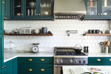 Kitchen - transitional l-shaped medium tone wood floor and brown floor kitchen idea in San Francisco with shaker cabinets, green cabinets, white backsplash, stainless steel appliances, an island and white countertops