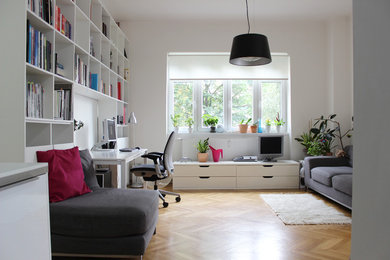 Trendy freestanding desk medium tone wood floor and beige floor home office photo in Other with white walls
