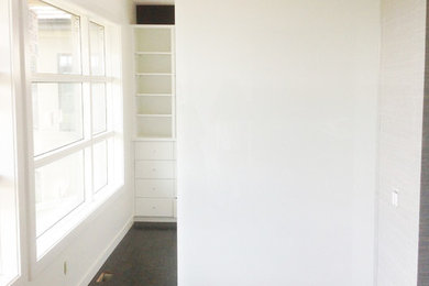 Inspiration for a mid-sized contemporary gender-neutral dark wood floor walk-in closet remodel in Edmonton with white cabinets