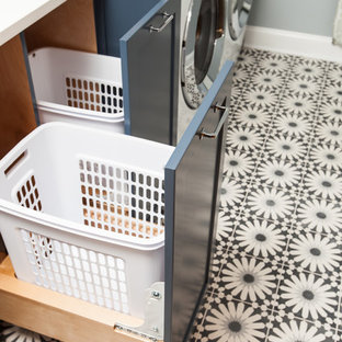 Ejemplo de cuarto de lavado lineal, moderno, de tamaño medio, con fregadero bajoencimera, armarios estilo shaker, puertas de armario azules, encimera de cuarzo compacto, paredes azules, suelo de cemento, lavadora y secadora juntas, suelo azul y encimeras blancas