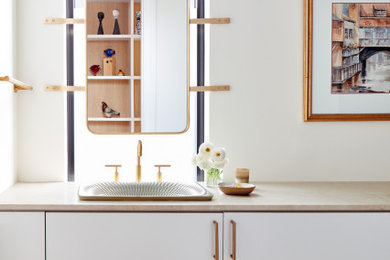 Trendy gray floor and single-sink bathroom photo in New York with flat-panel cabinets, white cabinets, white walls, a drop-in sink, beige countertops and a floating vanity