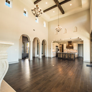This is an example of a large mediterranean open plan living room in Austin with grey walls, dark hardwood flooring, a standard fireplace and a stone fireplace surround.