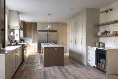 Inspiration for a large transitional u-shaped eat-in kitchen remodel in Portland with shaker cabinets, white cabinets, quartzite countertops, white backsplash, stainless steel appliances and an island