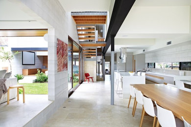 This is an example of an expansive contemporary kitchen/dining combo in Brisbane with grey walls and travertine floors.