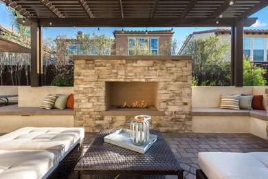 Inspiration for a large transitional backyard concrete paver patio remodel in Orange County with a fire pit and a pergola