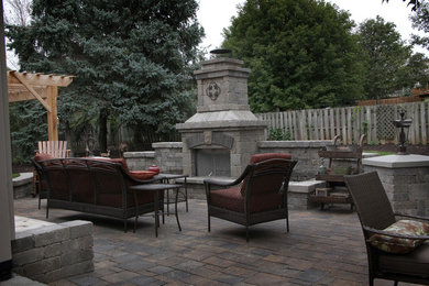 Large traditional backyard patio in Omaha with a fire feature, concrete pavers and no cover.