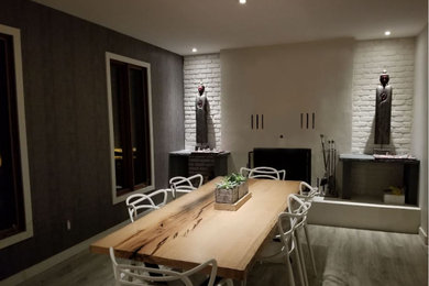 Inspiration for a brick wall kitchen/dining room combo remodel in Montreal with a wood stove and a concrete fireplace