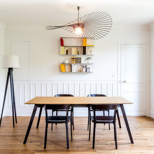 Réalisation d'une salle à manger design de taille moyenne et fermée avec un mur blanc, un sol en bois brun et aucune cheminée.