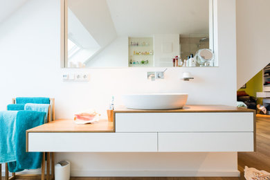 Badezimmer mit freistehender Badewanne, Waschtisch aus Holz, Einzelwaschbecken und schwebendem Waschtisch in Düsseldorf