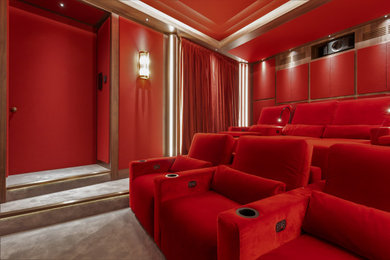 Ejemplo de cine en casa cerrado con paredes rojas, moqueta, pantalla de proyección y suelo gris