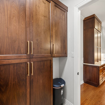 Walnut wood grain kitchen pantry cabinet with gold handles