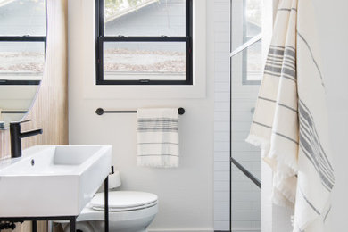 Photo of a small transitional master bathroom in Austin with black cabinets, an alcove shower, a two-piece toilet, multi-coloured tile, ceramic tile, white walls, terrazzo floors, a console sink, solid surface benchtops, black floor, an open shower, white benchtops, a single vanity and a freestanding vanity.