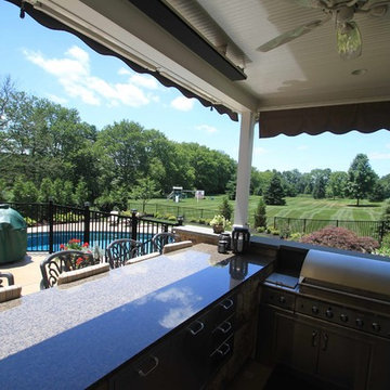 Kidney shaped in-ground salt water pool with outdoor kitchen