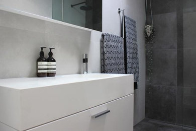 Photo of a mid-sized industrial master bathroom in Melbourne with white cabinets, an open shower, a one-piece toilet, gray tile, cement tile, white walls, cement tiles and a vessel sink.