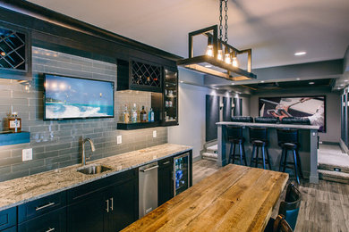 Example of a minimalist single-wall dark wood floor and brown floor wet bar design in DC Metro with an undermount sink, shaker cabinets, black cabinets, granite countertops, gray backsplash and subway tile backsplash