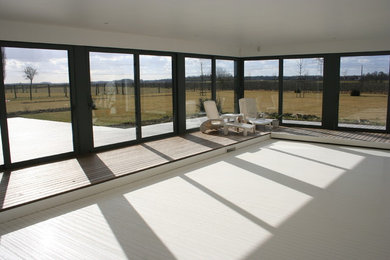 Exemple d'une grande piscine moderne rectangle avec une terrasse en bois.
