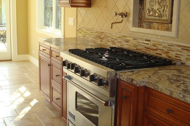 Large mountain style galley limestone floor and beige floor open concept kitchen photo with a farmhouse sink, beaded inset cabinets, medium tone wood cabinets, granite countertops, beige backsplash, mosaic tile backsplash, stainless steel appliances, an island and brown countertops