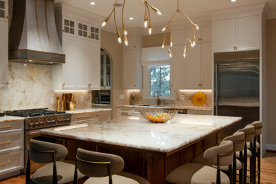 Mid-sized transitional l-shaped medium tone wood floor and brown floor open concept kitchen photo in Nashville with an undermount sink, recessed-panel cabinets, white cabinets, quartzite countertops, white backsplash, stone slab backsplash, stainless steel appliances, an island and white countertops