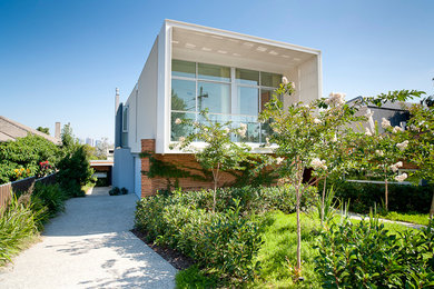 Photo of a mid-sized contemporary split-level exterior in Melbourne with a flat roof.