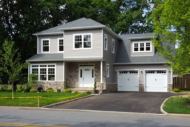 Inspiration for a mid-sized timeless gray two-story vinyl house exterior remodel in New York with a hip roof and a shingle roof