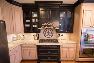 Enclosed kitchen - mid-sized traditional medium tone wood floor enclosed kitchen idea in Dallas with a farmhouse sink, distressed cabinets, granite countertops, beige backsplash, stone tile backsplash and stainless steel appliances