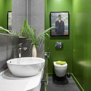 Exemple d'un WC et toilettes tendance avec un mur vert, une vasque, un sol gris et un plan de toilette blanc.