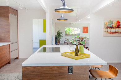 This is an example of a mid-sized midcentury galley open plan kitchen in San Francisco with an undermount sink, flat-panel cabinets, medium wood cabinets, quartz benchtops, multi-coloured splashback, ceramic splashback, stainless steel appliances, ceramic floors, with island and grey floor.
