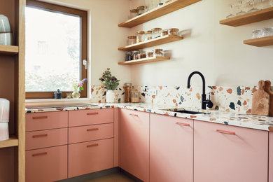 Geschlossene Moderne Schmale Küche ohne Insel in L-Form mit flächenbündigen Schrankfronten, pinken Schränken, Arbeitsplatte aus Terrazzo, Küchenrückwand in Beige und bunter Arbeitsplatte in Hamburg