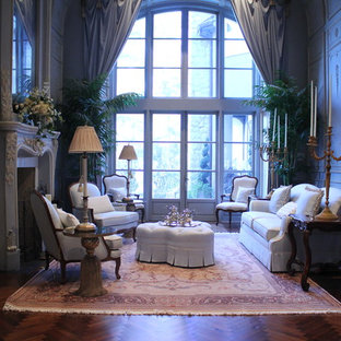 This is an example of a large mediterranean formal living room in Houston with blue walls, medium hardwood flooring, a standard fireplace, a plastered fireplace surround and no tv.