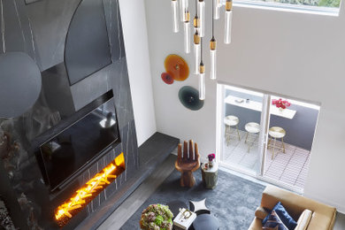 Mid-sized eclectic loft-style light wood floor, beige floor and vaulted ceiling living room photo in Orlando with white walls, a standard fireplace, a stone fireplace and a media wall