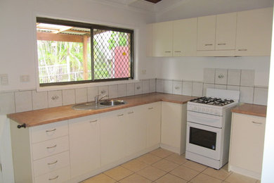 Photo of a mid-sized contemporary l-shaped kitchen pantry in Brisbane with no island.