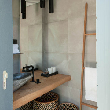 Birre bathroom with stone basin, ladder rack and wood vanity