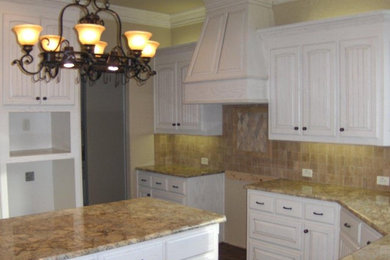 Photo of a large galley eat-in kitchen in Dallas with raised-panel cabinets, white cabinets, granite benchtops, beige splashback, stone tile splashback and with island.