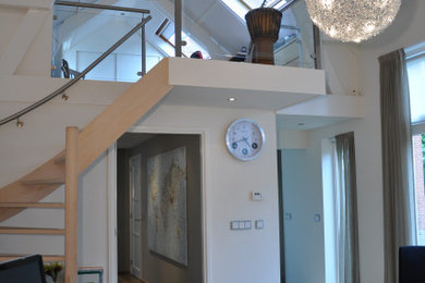 Imagen de despacho contemporáneo grande con paredes blancas, escritorio independiente, suelo beige, vigas vistas y suelo de madera en tonos medios