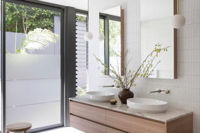 Inspiration for a modern bathroom in Sydney with flat-panel cabinets, light wood cabinets, a freestanding tub, white tile, a vessel sink, grey floor, beige benchtops, a double vanity and a floating vanity.