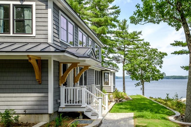 This is an example of a small contemporary two-storey grey house exterior in Portland Maine with a gable roof and a metal roof.